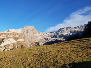 Scenic view of mountains against blue sky