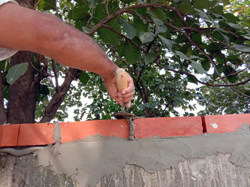 Midsection of man working against wall