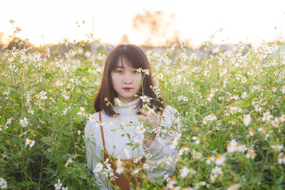 Portrait of beautiful young woman on field