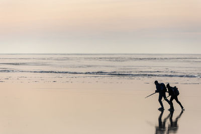 People long-distance skating at sunset, vanern, sweden