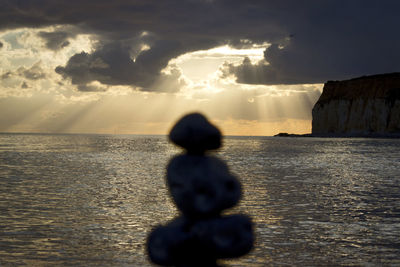 Rear view of silhouette boy on beach against sky during sunset