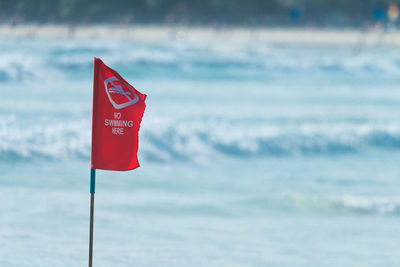 Close-up of red flag against the sky