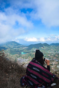 Rear view of woman looking at mountains against sky