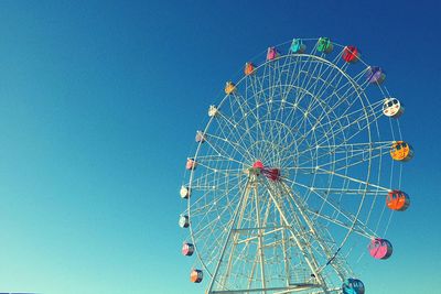 Low angle view of ferris wheel against blue sky