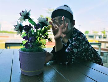 Woman looking at potted plant on table