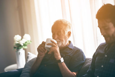 Man looking at camera while sitting at home