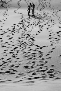 Low section of man walking on beach