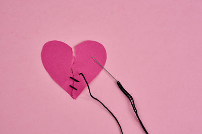 Close-up of heart shape against pink background