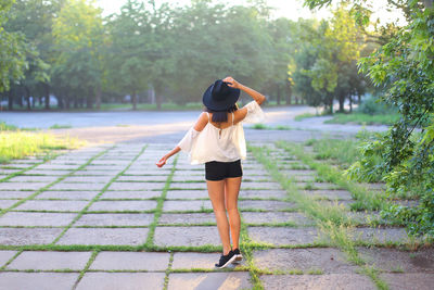 Rear view of woman standing on road