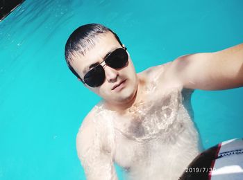 Portrait of shirtless boy swimming in pool