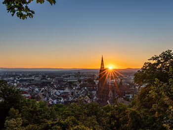 Aerial view of buildings in city at sunset