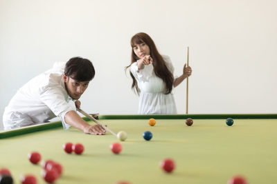 Young woman playing with ball on table