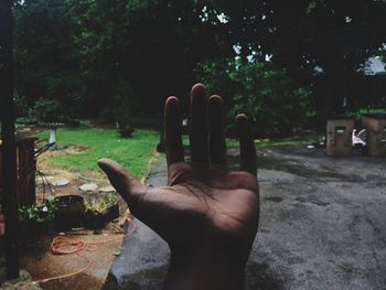 Close-up of hand against road