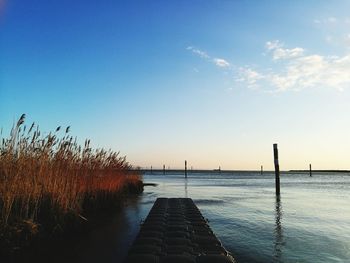 Jetty on pier against blue sky