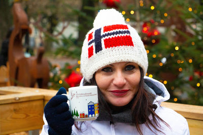 Portrait of woman with hat on christmas tree