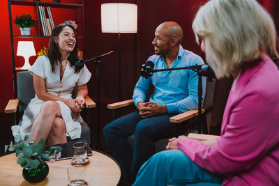 Portrait of smiling friends using mobile phone