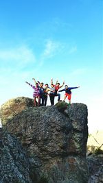 Low angle view of people on rock formation