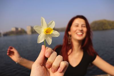 Midsection of woman with red flower in water