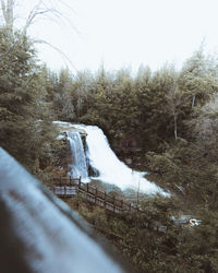 Scenic view of waterfall in forest against clear sky