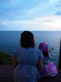 Rear view of woman looking at sea against sky