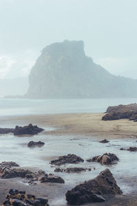 Scenic view of sea and mountains against sky