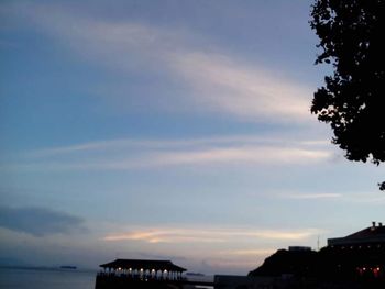 Scenic view of landscape against cloudy sky at sunset