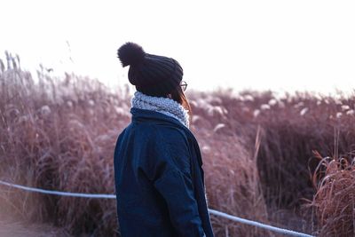 Woman standing against plants during winter