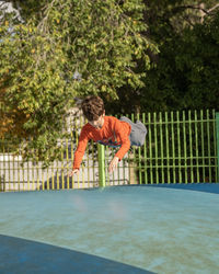 Kid playing and having fun while jumping on large inflatable bouncing trampoline upside down.