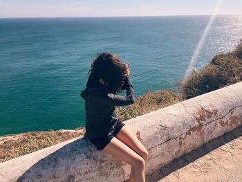 Portrait of woman on beach by sea against sky