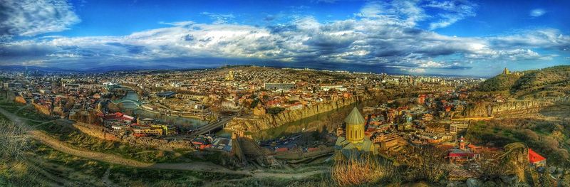 Trees on field against cloudy sky