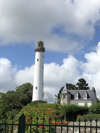 Low angle view of lighthouse by building against sky. leuchtturm haus natur
