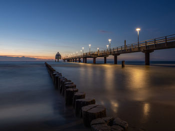 Pier over sea against sky during sunset