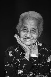 Portrait of a smiling woman against black background