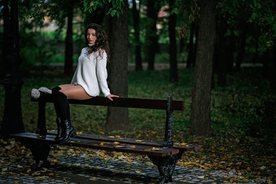 Woman sitting on bench in forest