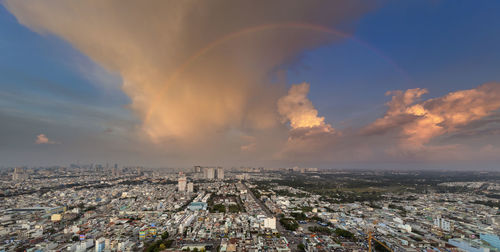 Aerial view of illuminated city against sky during sunset