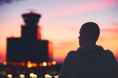 Rear view of man against sky at sunset