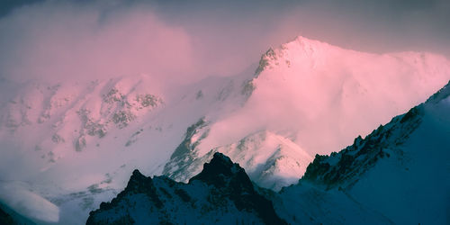 Scenic view of snowcapped mountains against sky during sunset