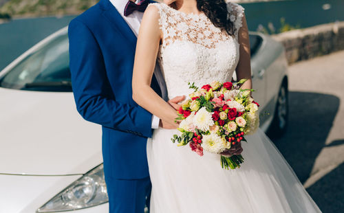 Midsection of woman holding flower bouquet