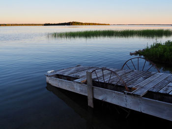 Pier over lake against sky during sunset