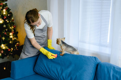 Side view of boy playing with dog at home