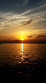 Scenic view of sea against dramatic sky during sunset