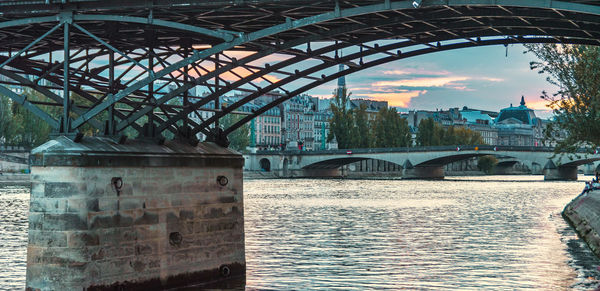 Bridge over river in city against sky