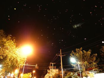 Low angle view of illuminated street lights at night