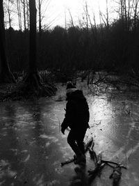 Rear view of person walking on snow covered landscape