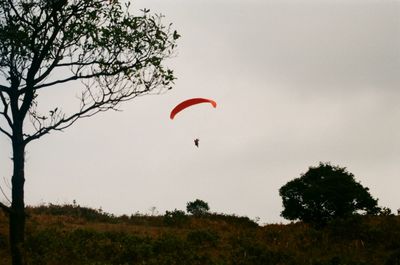 Low angle view of person paragliding against clear sky