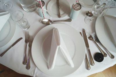 Directly above shot of plates and eating utensils arranged on restaurant table