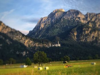 Scenic view of field and mountains against sky