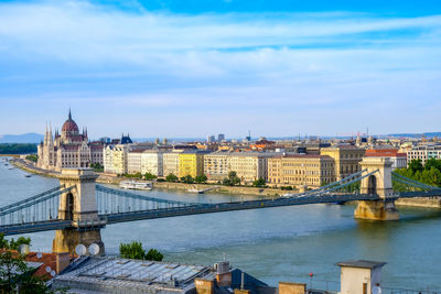 View of bridge over river in city against sky