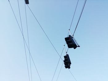Low angle view of overhead cable car against clear blue sky