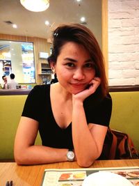 Portrait of young woman sitting at restaurant